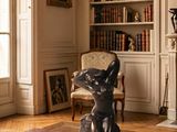 une statue représentant un chien assis sur une table dans un salon