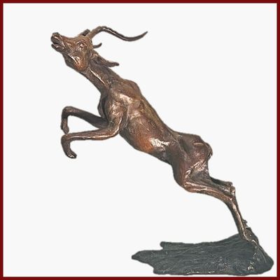 statue en bronze représentant un cerf bondissant sur un rocher, sur fond blanc
