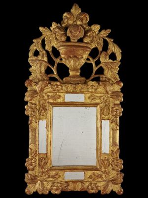 une image représentant un miroir doré sur lequel est posé un vase