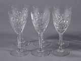 three clear wine glasses sitting next to each other on a table