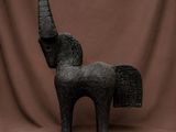 sculpture représentant un cheval doté d'une longue corne, sur fond marron