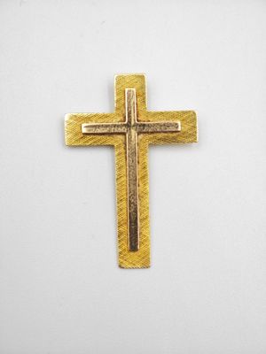 pendentif en forme de croix plaqué or sur fond blanc