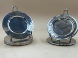 deux assiettes en argent ornées d'une horloge, posées sur une table