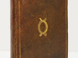 un vieux livre en cuir marron orné d'un emblème doré sur la couverture