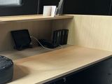 a black bag sitting on a wooden desk next to a computer monitor