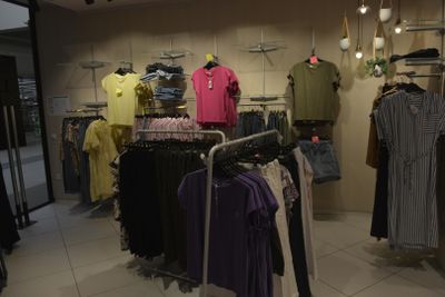 a lot of clothes hanging on a rack in a store