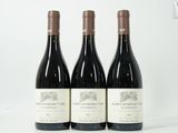 trois bouteilles de vin rouge posées sur une table blanche