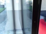 a red chair sitting in front of a glass door