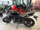 a red and black motorcycle parked in a showroom
