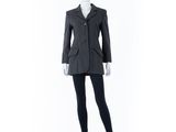 Le mannequin porte un tailleur noir et un legging noir.