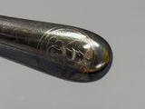 a close up of a silver spoon with a black handle