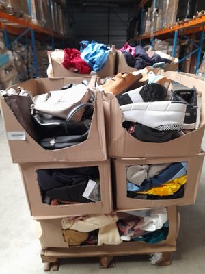 de nombreux cartons de vêtements sur un chariot dans un entrepôt