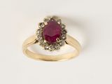 un gros plan d'une bague en or sertie d'un rubis entouré de diamants blancs