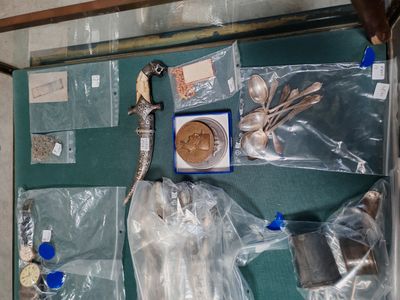 vue de dessus d'une valise remplie d'argenterie et d'autres objets