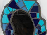 a blue and yellow mirror with a bird on it