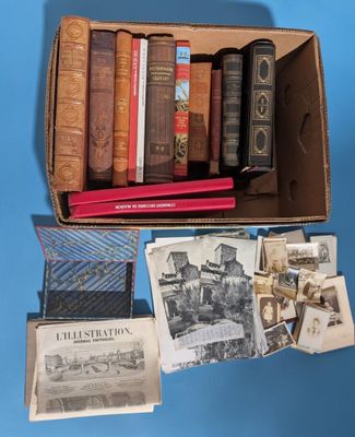 many old books in a box on a blue surface