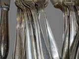 a lot of forks and spoons hanging from a rack