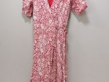 une robe à fleurs rouges et blanches suspendue à un cintre