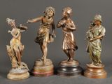 quatre figurines en bronze représentant des femmes tenant des fleurs et posées sur des socles