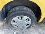 a close up of a tire on the side of a yellow car