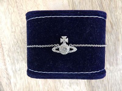 a close up of a blue velvet box with a silver bracelet on it