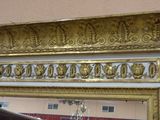 a mirror with a gold frame hanging on the wall