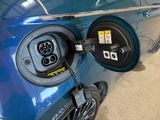 a blue car that has an electric charger attached to it