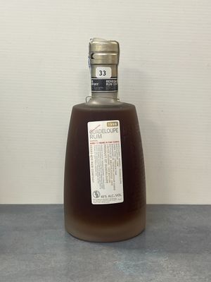 une bouteille d'alcool posée sur un comptoir à côté d'une autre bouteille d'alcool