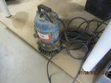 une machine posée par terre à côté de quelques fils