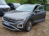 the volkswagen suv is parked next to other cars on the side of the road