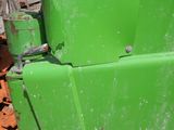 a close up of a green tractor parked on the side of the road