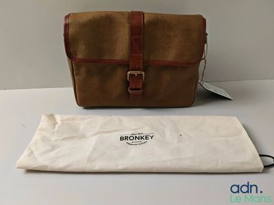 Le sac marron est posé à côté d'un sac blanc sur une table.