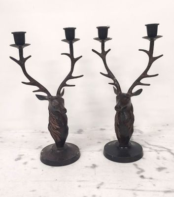paire de bougeoirs en bronze en forme de tête de cerf, avec des bougies noires