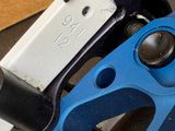 a close up of a clamp with a blue handle