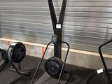 a gym room with a row of stationary exercise equipment