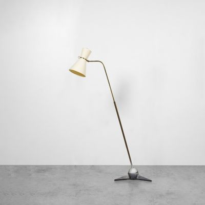un lampadaire avec un pied en métal et un abat-jour blanc