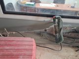 une photo d'une perceuse filaire posée par terre devant une fenêtre