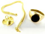 une image représentant une bague en or, une pierre noire et une chaîne en or