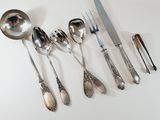 a lot of silver spoons and knives on the table