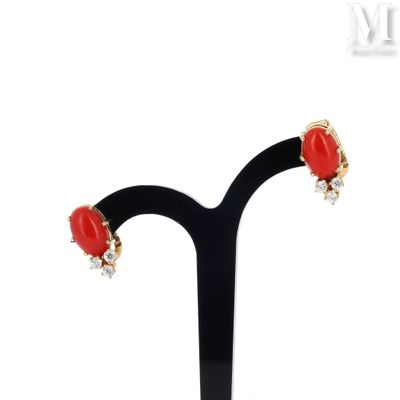 a close up of a pair of earrings on a black stand
