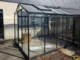 une image représentant une grande serre en verre avec un toit