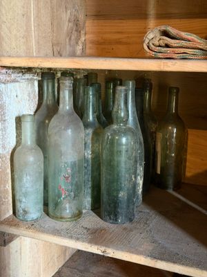 de nombreuses bouteilles vides posées sur une étagère dans une pièce
