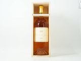 une bouteille de vin dans un coffret en bois posée sur une surface blanche