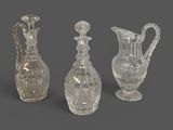 trois vases en cristal taillé et une carafe sur fond gris