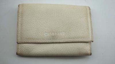un portefeuille en cuir blanc posé sur une table blanche