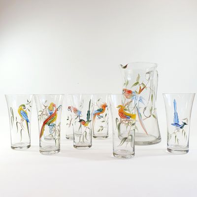 seven glasses and a pitcher with birds painted on them