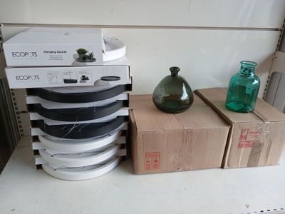 a stack of boxes and a green vase on a table