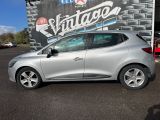une voiture argentée garée devant un immeuble, avec une grande enseigne sur le côté