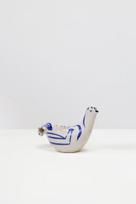 une paire de figurines d'oiseaux bleues et blanches posées sur un support blanc