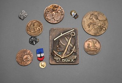 many coins and a medal laying on a table